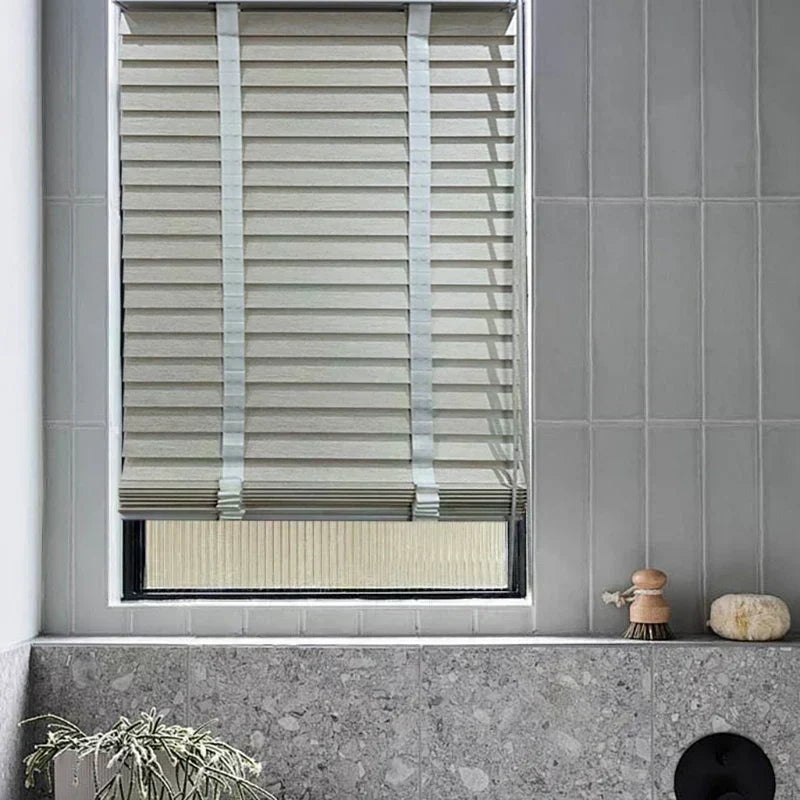 Faux wood venetian blinds installed in a modern bathroom — horizontal slats partially raised, showing light control through tilted slats