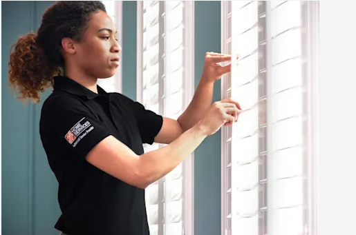 Professional measuring a window for custom cellular shade installation, demonstrating precise window measurement technique for inside mount blinds