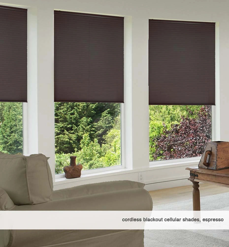 Three cordless dark blackout cellular window shades mounted on picture windows in a modern peaceful bedroom
