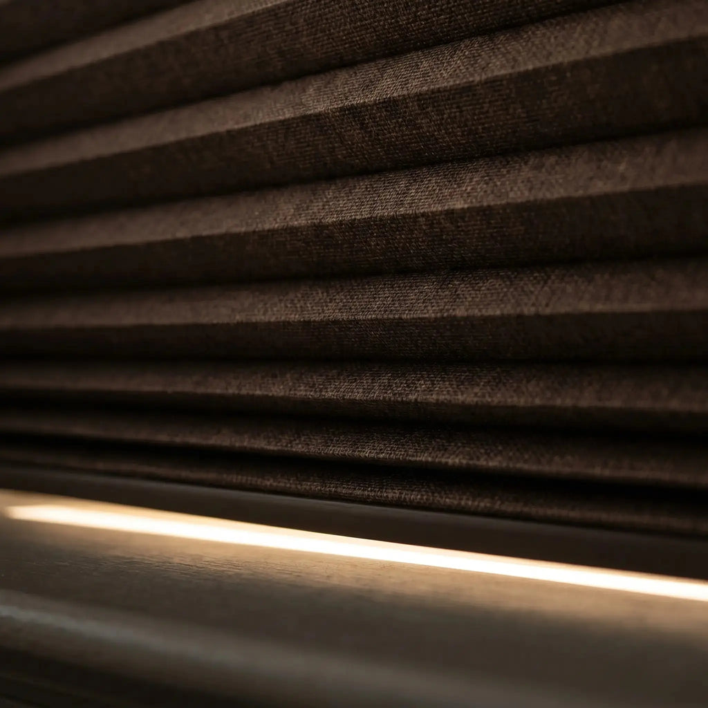 Close up of dark blackout honeycomb cellular shade fabric with insulating air pocket chambers and light block rail
