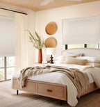 Custom cordless blackout roller shades in a warm modern bedroom with wooden platform bed and neutral decor
